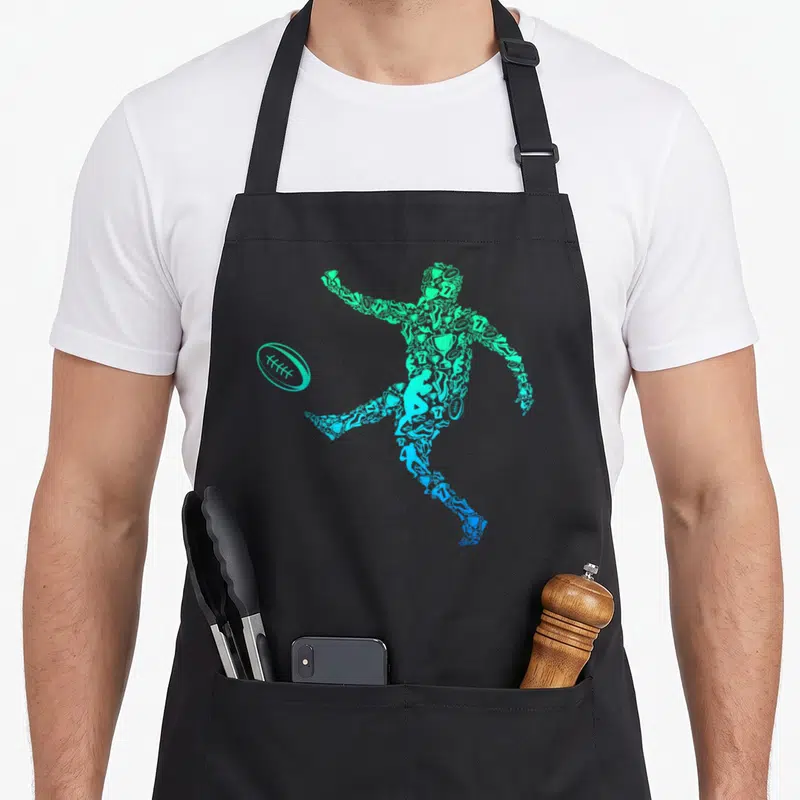 Tablier de cuisine noir avec une silhouette de joueur de rugby composée de petits dessins sportifs dans des tons bleu et vert menthe.