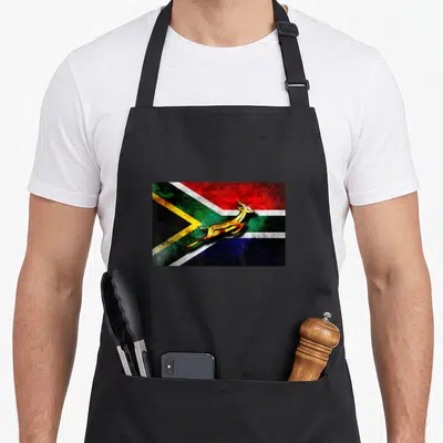 Tablier de cuisine noir avec illustration du Springbok Bokke sur le drapeau sud-africain aux couleurs vives et effet vieilli.