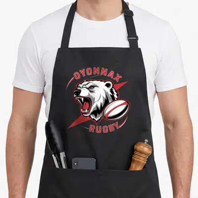 Tablier de cuisine noir avec tête d'ours polaire rugissant et ballon de rugby rouge et blanc.