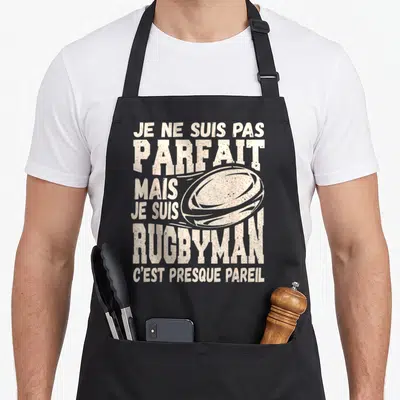 Tablier de cuisine noir avec inscription Je ne suis pas parfait mais je suis rugbyman et illustration de ballon.