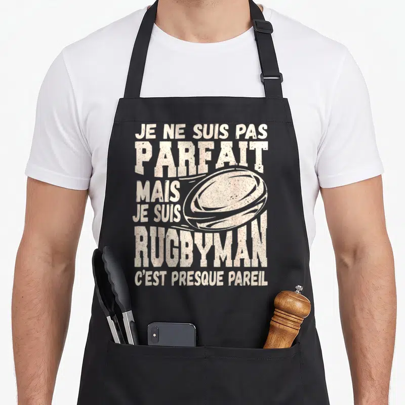 Tablier de cuisine noir avec inscription Je ne suis pas parfait mais je suis rugbyman et illustration de ballon.