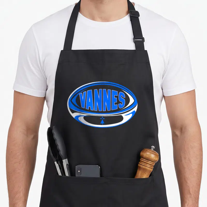 Tablier de cuisine noir avec un logo ovale bleu blanc affichant le mot Vannes et une croix bretonne stylisée.