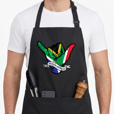 Tablier de cuisine noir avec une main peinte aux couleurs du drapeau sud-africain et un ruban portant l'inscription South Africa.