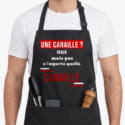 Tablier de cuisine noir avec une inscription rouge et blanche sur fond gris unie.