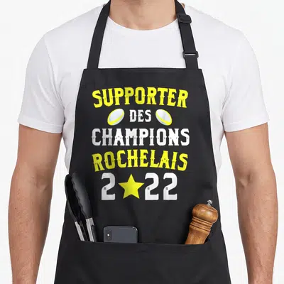 Tablier de cuisine noir avec texte Supporter des Champions Rochelais 2022 en jaune et blanc.