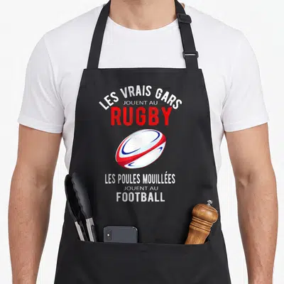 Tablier de cuisine noir avec illustration de ballon de rugby et texte humoristique Les Vrais Gars Jouent au Rugby Football
