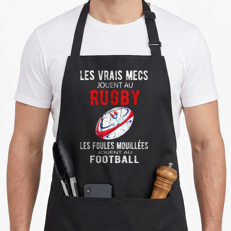 Tablier de cuisine noir avec texte Les Vrais Mecs Jouent Au Rugby et ballon de rugby orné d'un coq tricolore.