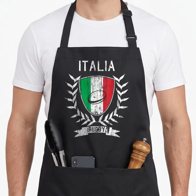 Tablier de cuisine noir avec un blason Italia Rugby aux couleurs vertes, blanches et rouges entouré de lauriers blancs.
