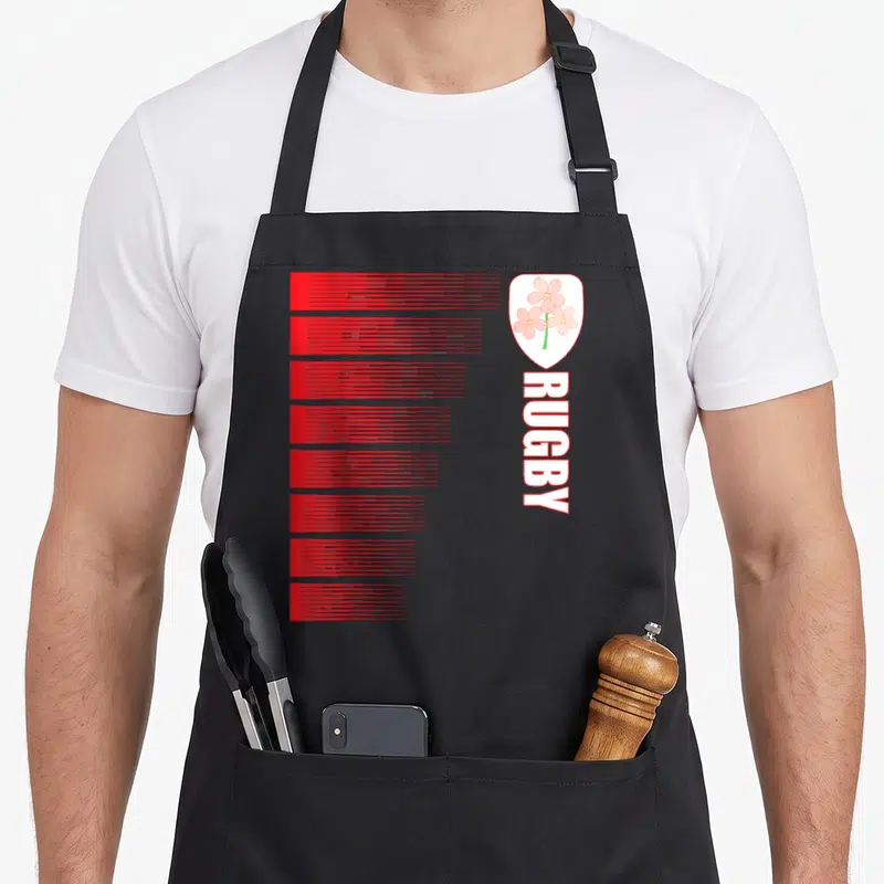 Tablier de cuisine noir avec bandes rouges horizontales et blason fleur de sakura verticalement aligné à droite.
