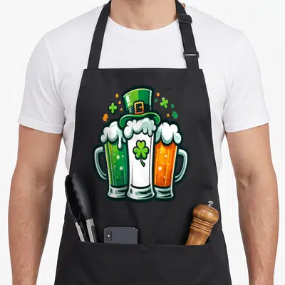 Tablier de cuisine noir avec illustration de trois verres de bière verts blancs et oranges surmontés d'un chapeau haut de forme vert.