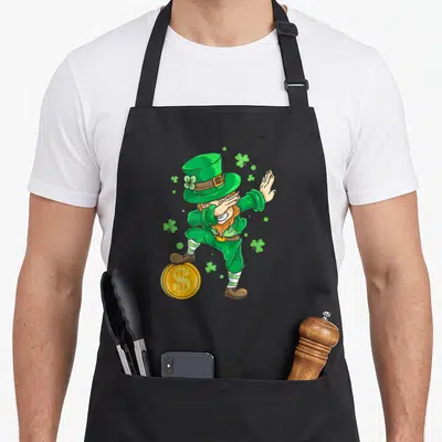 Tablier de cuisine noir avec illustration colorée d'un leprechaun effectuant le dab sur une pièce d'or dorée.