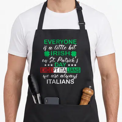 Tablier de cuisine noir avec texte vert blanc et drapeau italien tricolore sur le bas du motif imprimé.