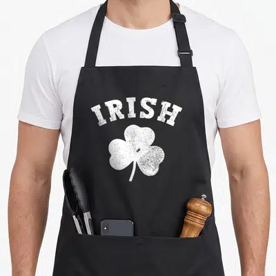 Tablier de cuisine noir avec inscription IRISH et illustration de trèfle blanc au design vieilli