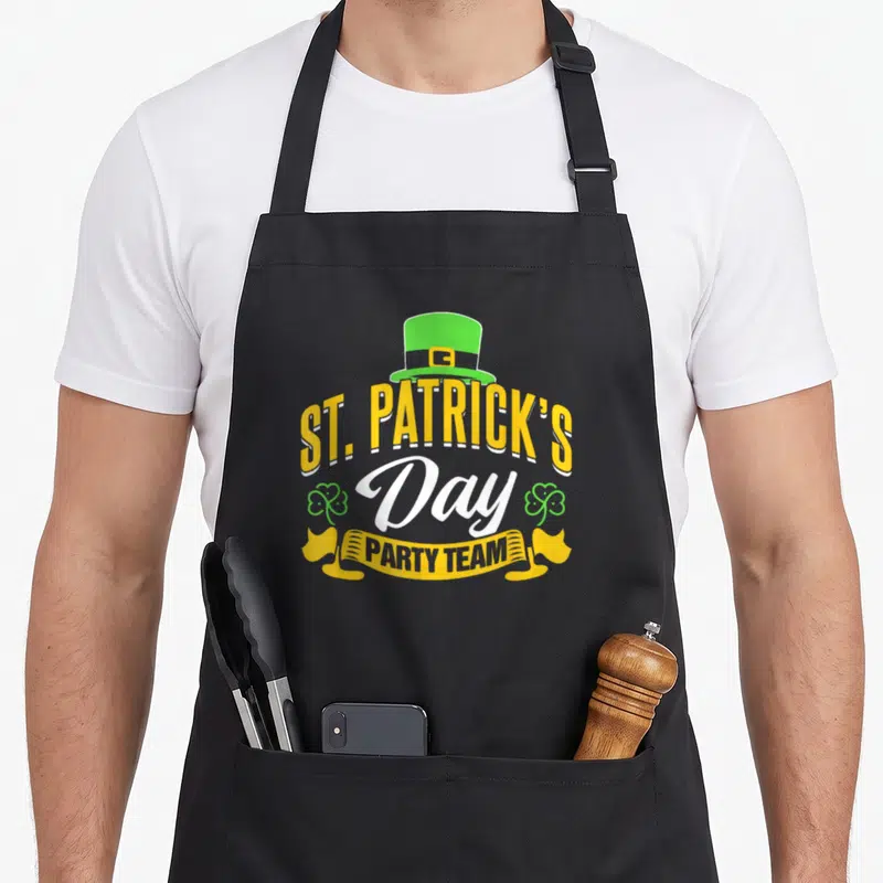 Tablier de cuisine noir avec inscription St Patrick's Day Party Team et chapeau vert.