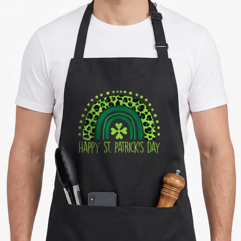 Tablier de cuisine noir avec arc-en-ciel motif léopard vert et texte Happy St Patrick's Day en bas.