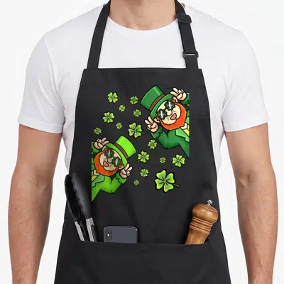 Tablier de cuisine noir avec deux leprechauns en lunettes de soleil trèfle et paume de la main verte.