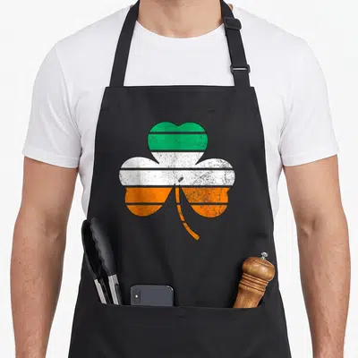 Tablier de cuisine noir avec un grand trèfle aux couleurs du drapeau irlandais vert blanc et orange