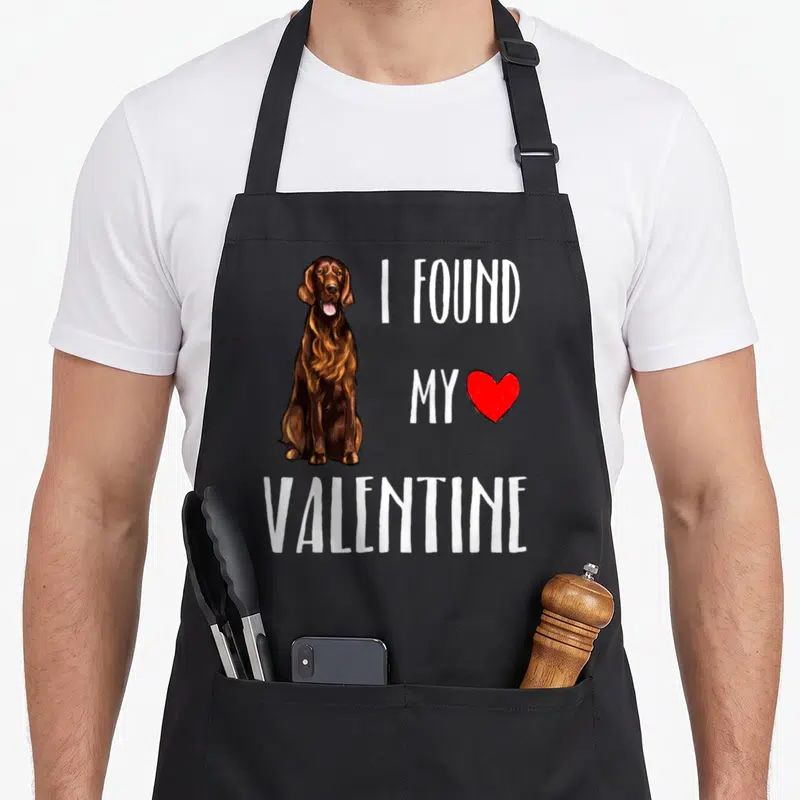 Tablier de cuisine noir avec illustration d'un setter irlandais et texte blanc J'ai trouvé mon Saint Valentin accompagné d'un cœur rouge.