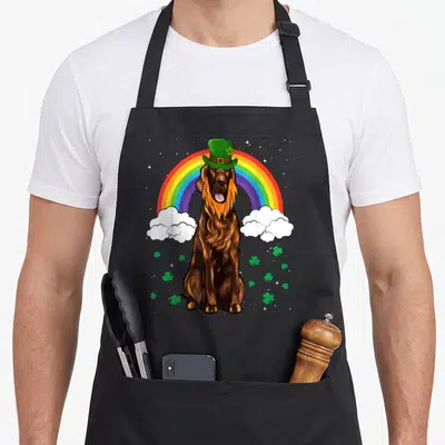 Tablier de cuisine noir avec illustration d'un setter irlandais portant un chapeau vert sur fond darc-en-ciel et trèfles.