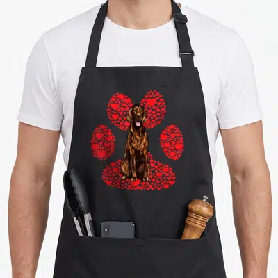 Tablier de cuisine noir avec illustration d'un setter irlandais assis devant une patte canine composée de petits cœurs rouges vifs.