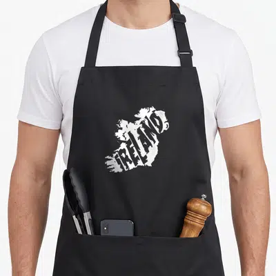 Tablier de cuisine noir avec carte de l'Irlande blanche formée par le mot Ireland en typographie stylisée.