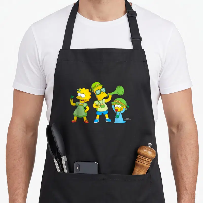 Tablier de cuisine noir avec Lisa, Bart et Maggie des Simpson en tenue verte pour la Saint Patrick.