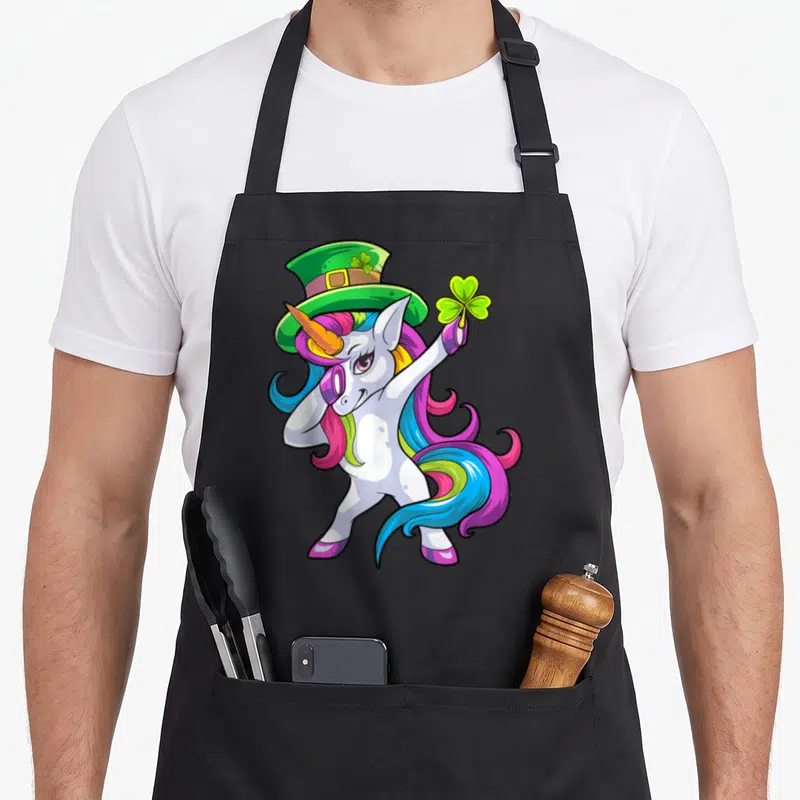 Tablier de cuisine noir avec illustration colorée d'un lepricorn effectuant un dab sous un chapeau vert.