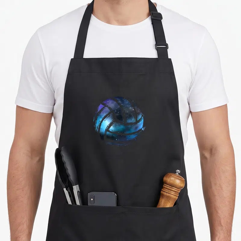 Tablier de cuisine noir avec un ballon de volley-ball aux teintes galactiques bleues et violettes.