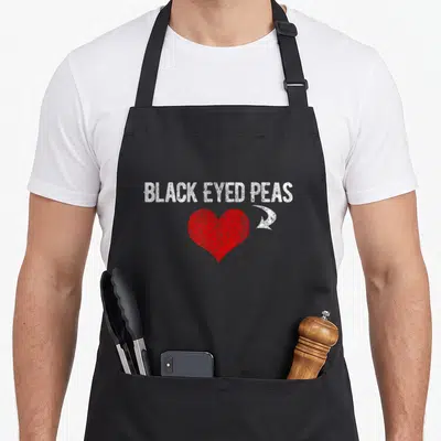 Tablier de cuisine noir avec inscription White Black Eyed Peas et un grand cœur rouge au centre du vêtement.