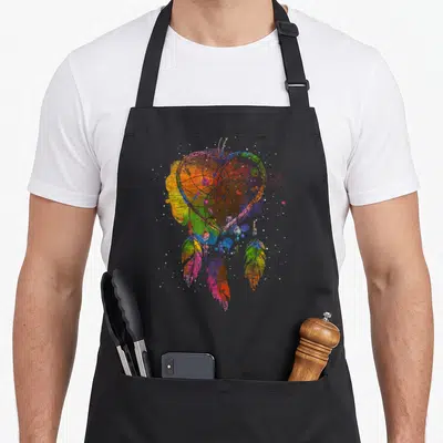 Tablier de cuisine noir avec un attrape-rêves cœur multicolore style aquarelle et texture.