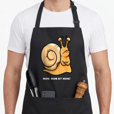 Tablier de cuisine noir avec illustration d'un escargot jaune aux bras croisés et texte blanc Non non et non en bas du motif.