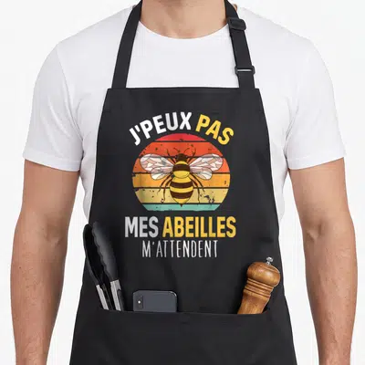 Tablier de cuisine noir avec illustration d'abeille et texte J'peux pas mes abeilles m'attendent en style vintage.