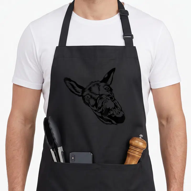Tablier de cuisine noir avec illustration d'un visage d'âne aux dents apparentes et expression comique.