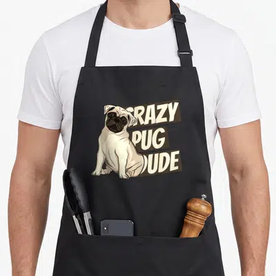 Tablier de cuisine noir avec illustration d'un pug assis et texte Crazy Pug Dude en lettres capitales blanches sur fond marron.