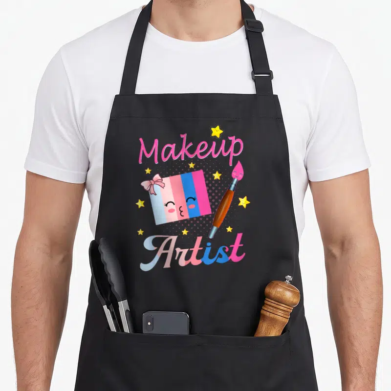 Tablier de cuisine noir avec illustration colorée d'une palette de maquillage et d'un pinceau aux étoiles jaunes.