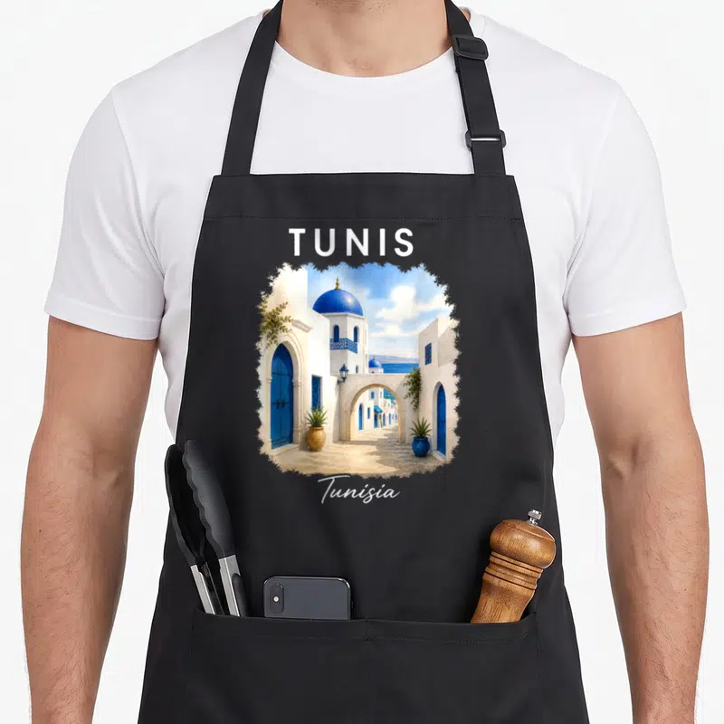 Tablier de cuisine noir avec illustration des ruelles bleues et blanches de Tunis en Tunisie.