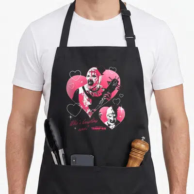 Tablier de cuisine noir avec un monstre sanglant dans des cœurs roses et le texte Who's laughing now.