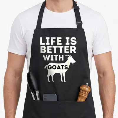 Tablier de cuisine noir avec silhouette chèvre blanche et texte Life Is Better With Goats en lettres capitales.