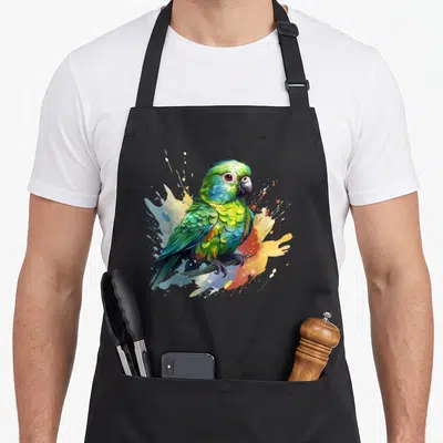 Tablier de cuisine noir avec une illustration colorée d'une perruche aux plumes vertes et bleues sur fond de taches artistiques.