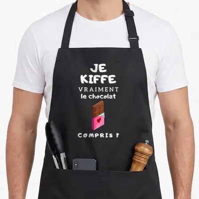 Tablier de cuisine noir avec une barre de chocolat rose et le texte Je kiffe vraiment le chocolat compris