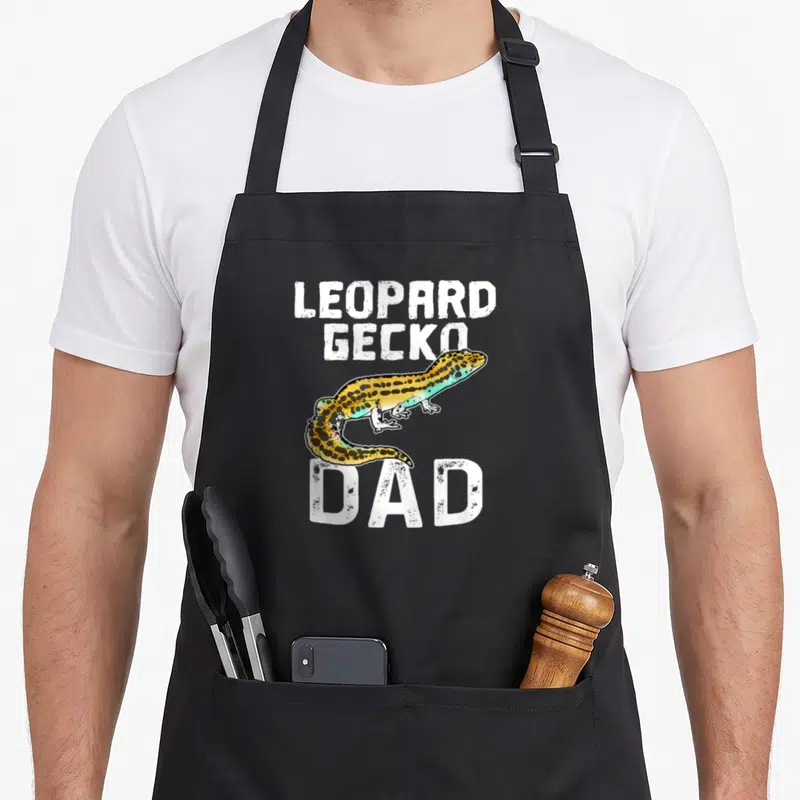 Tablier de cuisine noir avec illustration colorée d'un lézard leopard gecko et le texte blanc « LEOPARD GECKO DAD » imprimé au centre.