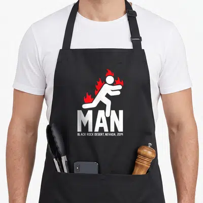 Tablier de cuisine noir avec une silhouette blanche enflammée et le texte MAN Black Rock Desert Nevada 2019 imprimé au centre.