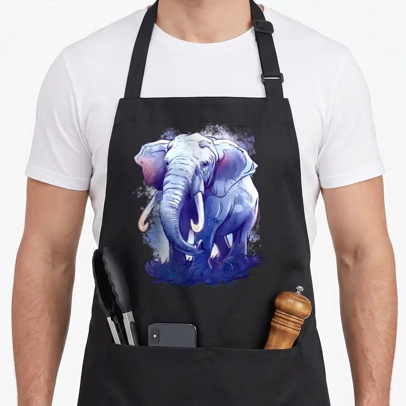 Tablier de cuisine noir avec un éléphant dessiné en aquarelle aux teintes bleues et violettes, entouré d'éclaboussures artistiques.