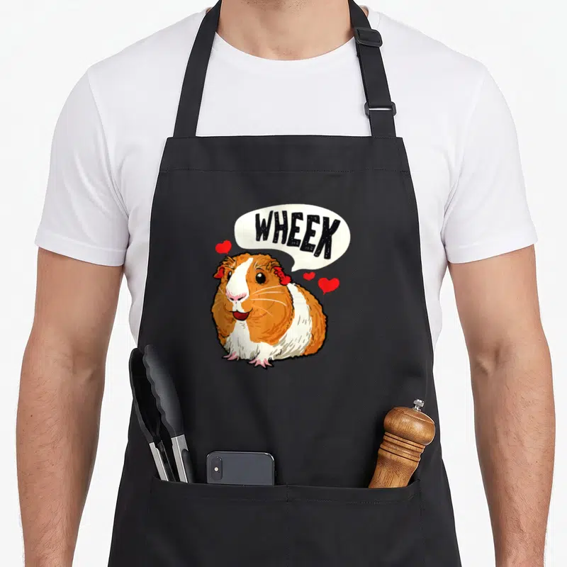 Tablier de cuisine noir avec illustration colorée d'un cochon d'Inde et bulle de dialogue Wheek