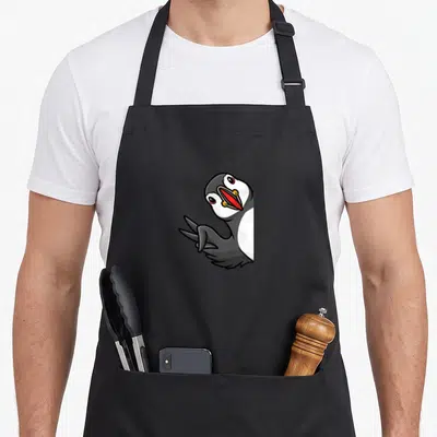 Tablier de cuisine noir avec illustration d'un macareux moine aux yeux rouges et bec coloré.