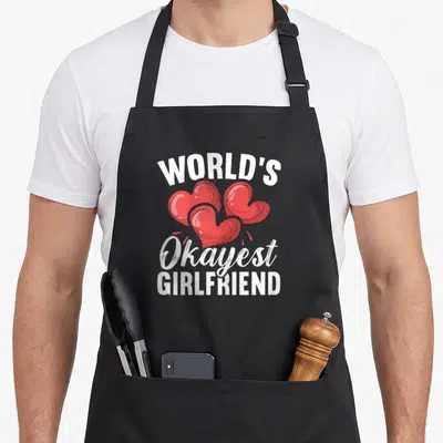 Tablier de cuisine noir avec trois cœurs rouges et le texte blanc World's Okayest GirlfriendGirlfriend