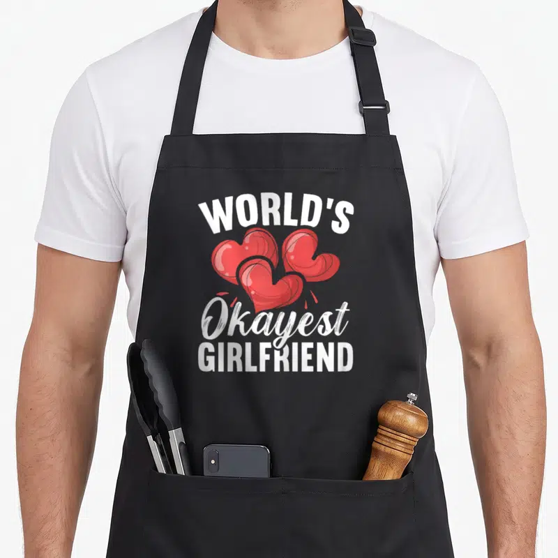 Tablier de cuisine noir avec trois cœurs rouges et le texte blanc World's Okayest GirlfriendGirlfriend
