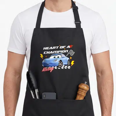 Tablier de cuisine noir avec illustration de voiture bleue Sally et texte Heart of a Champion Racing.