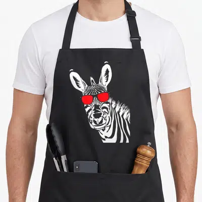 Tablier de cuisine noir avec tête de zèbre stylisée en noir et blanc portant des lunettes de soleil à verres rouges vifs.