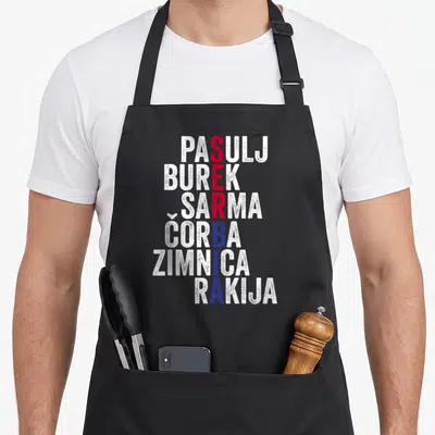 Tablier de cuisine noir avec typographie listant des plats serbes en blanc, rouge et bleu.